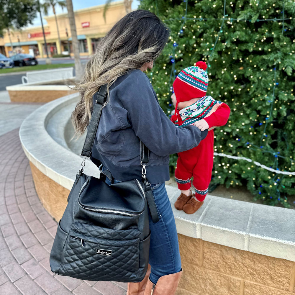 Bellaboo Mabel Baby Changing Bag Onyx Black Worn On The Shoulder With A Mum And Baby